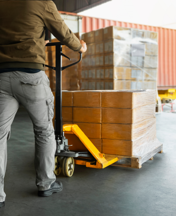 trabajadores-descargando-cajas-embalaje-paletas-al-almacen-envio-camiones-contenedores-carga 1guy montarcargas Almacen Real Logistics
